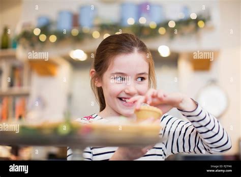 Smiling Girl Eating Christmas Cupcake Stock Photo Alamy