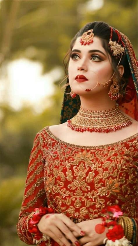 A Woman In A Red And Gold Bridal Outfit With Jewelry On Her Head