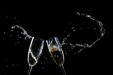 Premium Photo Glasses Of Champagne With Splash On Black Background