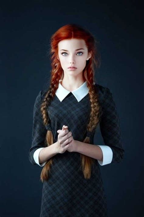 A Woman With Red Hair And Braids Standing In Front Of A Black Background Wearing A Dress