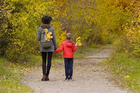 Premium Photo Mom And Son Are Walking In The Autumn Forest Back View