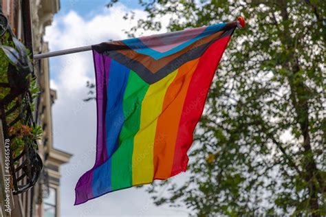 Progress Pride Flag New Design Of Rainbow Flag Waving In The Air With Blue Sky Symbol Of Gay