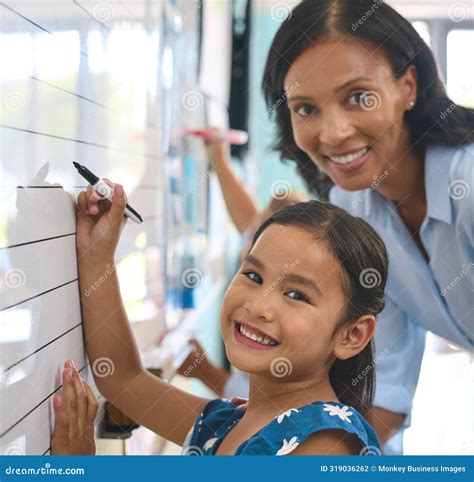 Portrait Of Primary Or Elementary School Student With Teacher Writing