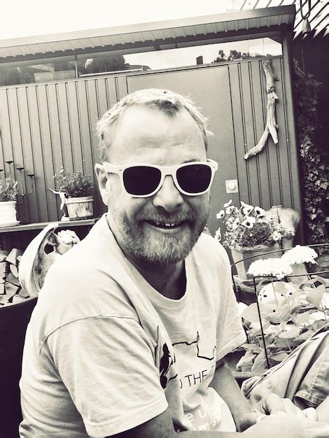 Premium Photo Portrait Of Man Wearing Sunglasses While Sitting In Yard