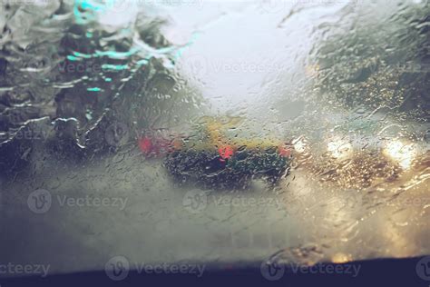 Drops Of Rain Drizzle On The Glass Windshield In The Evening Street In