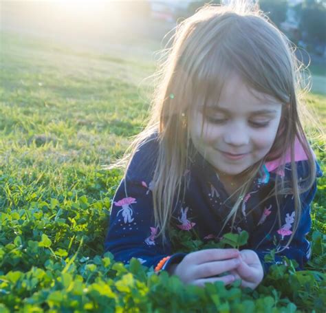 Premium Photo Smiling Girl Holding Leaves While Lying On Plants