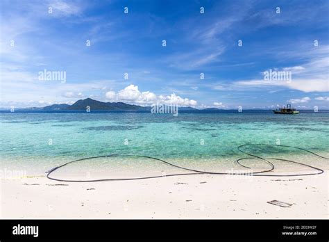white sand beach  plastic garbage semporna malaysia stock photo