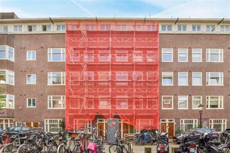 A Large Brick Building With A Red Scaffolding Covered Editorial Stock