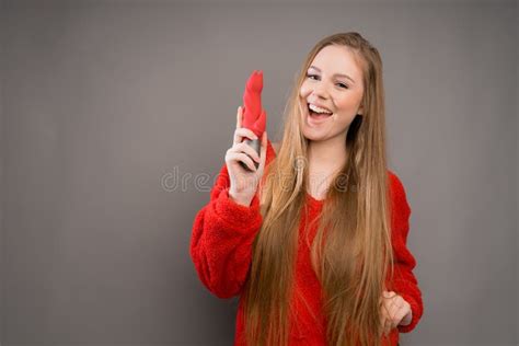 A Beautiful Italian Girl In A Red Sweater Happily Holds A Vibrator Or A In Her Hands For Sex