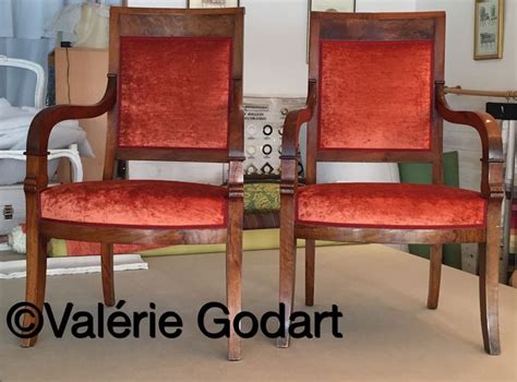 Two Red Chairs Sitting Next To Each Other On Top Of A Carpeted Floor In