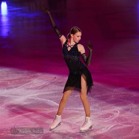 A Female Figure Skating On The Ice In A Black Leotard Dress And Gloves