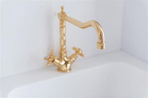 Premium Photo | Gilded water tap on white kitchen in new interior design