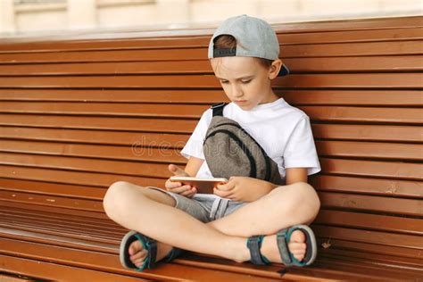 Boy Playing Mobile Games On Phone Teenager With Smartphone Sitting On