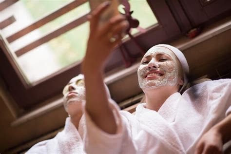 Premium Photo Beautiful Young Women Getting Facial Clay Mask At Spa