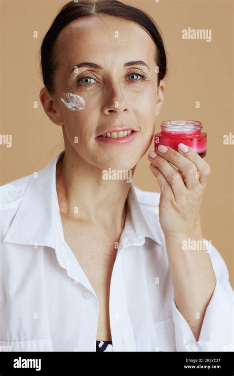 Modern 40 Years Old Woman With Facial Cream Jar In White Shirt Isolated