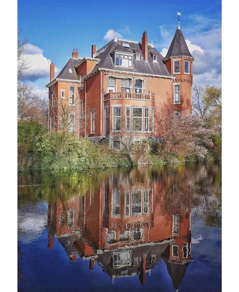 An Old Brick Building Is Reflected In The Water