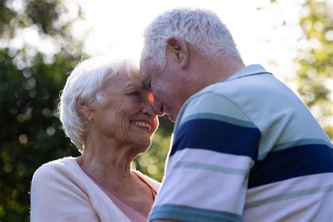 Premium Photo Happy Caucasian Senior Couple Embracing And Looking At Themselves In Sunny