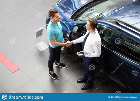 Vendedor De Coches Joven Que Sacude Las Manos Con El Cliente Imagen De