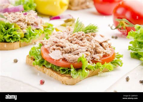 Tuna Sandwiches With Lettuce Tomatoes And Onions On Parchment Paper