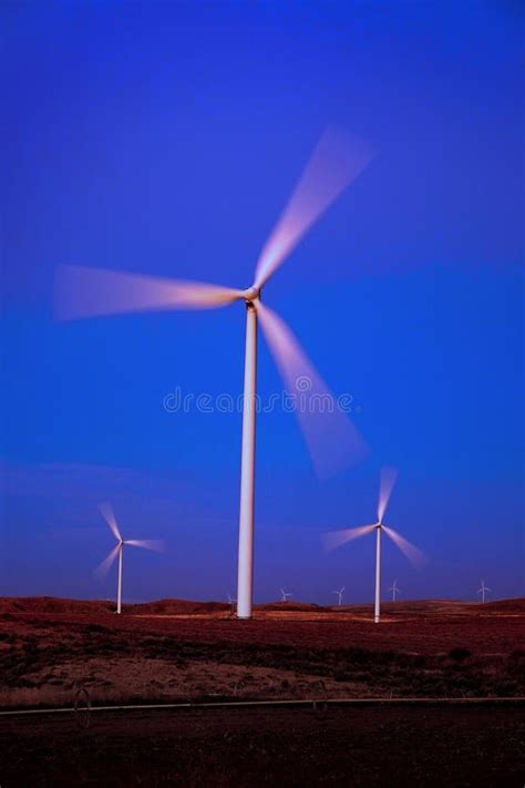 Windmill Wind Turbine Spinning In Wind At Sunset Or Sunrise Stock Image