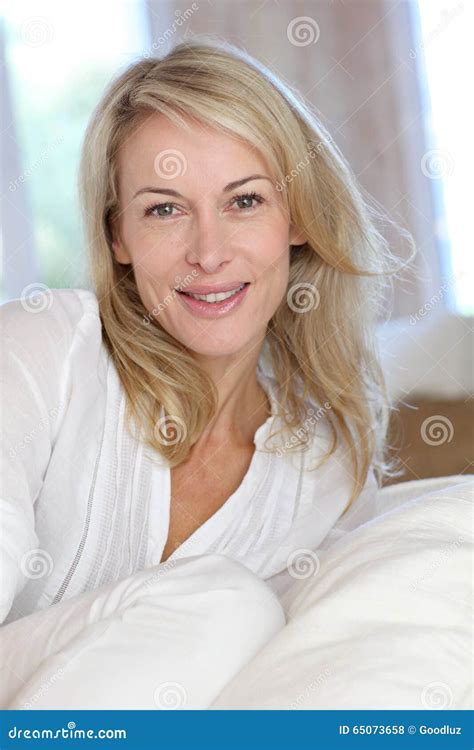 Blonde Reife Frau Die Auf Sofa Sitzt Stockfoto Bild Von Recht Vierziger 65073658