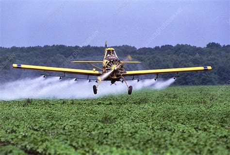 Aircraft spraying a cotton field with insecticide - Stock Image - E776/0076 - Science Photo Library