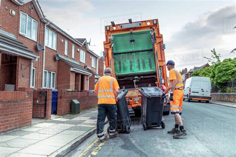 Refuse collectors with bins and refuse truck in street - Stock Photo ...