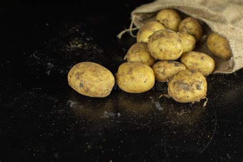 Vuile Ruwe Aardappels Op Een Plaat Op Lijst Met Knoflook En Peper Stock