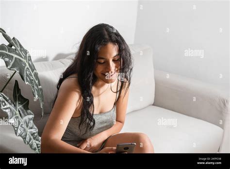 Brunette Girl Sitting On Couch Checking Her Cell Phone Woman Smiling