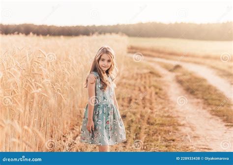 Belle Petite Fille Blonde Aux Cheveux Longs Marchant à Travers Le Champ