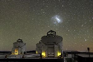 Two Bright Magellanic Clouds Above The Auxiliary Telescopes Of VLT