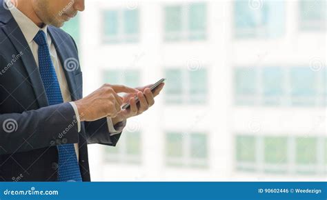 Close Up Hand Of Businessman Using Mobile Phone Near Office Wind Stock