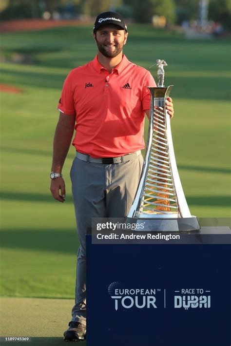 Jon Rahm Of Spain Poses With The Race To Dubai Trophy Following His