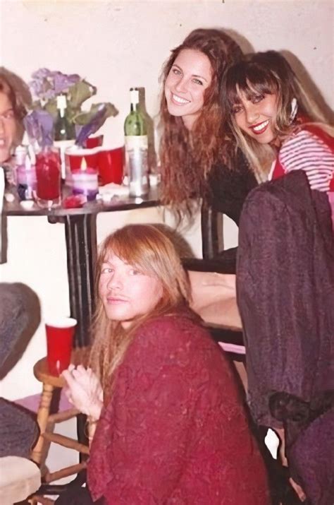 Four People Sitting At A Table With Drinks And Wine Bottles On It