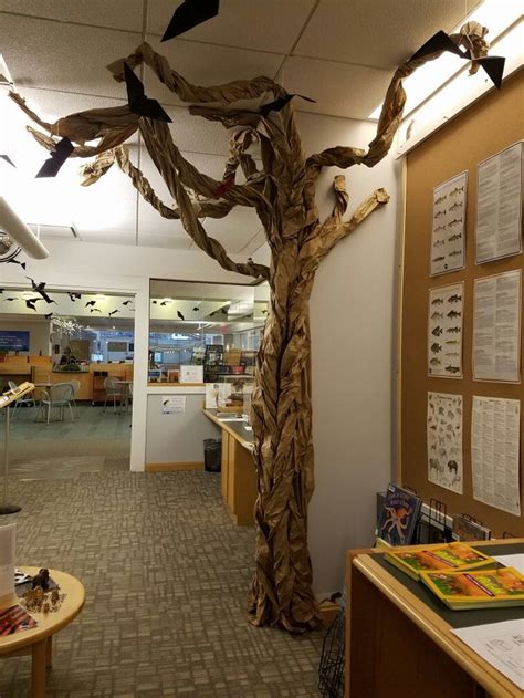 An Office Decorated With Fake Branches And Birds