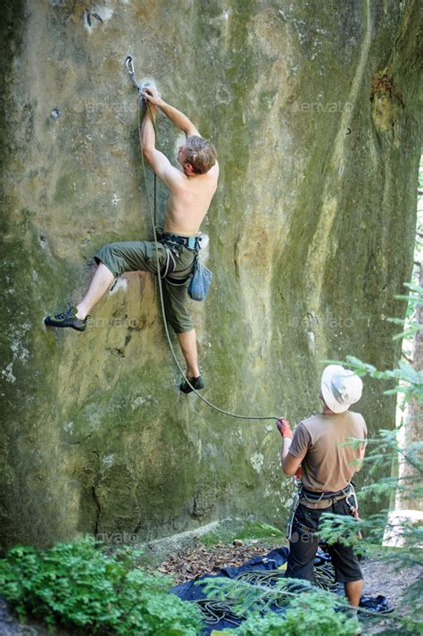 Muscular Rock Climber Climbs On Cliff Wall With Rope Stock Photo By