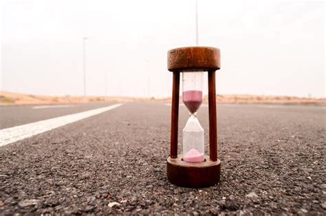 Premium Photo Time Concept Alarm Hourglass On The Asphalt Street