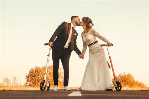 Novios besándose en scooters a lo largo de la carretera fuera de la