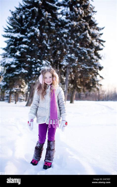 Cute funny kid girl 5-6 year old walk in snowy park over nature ...