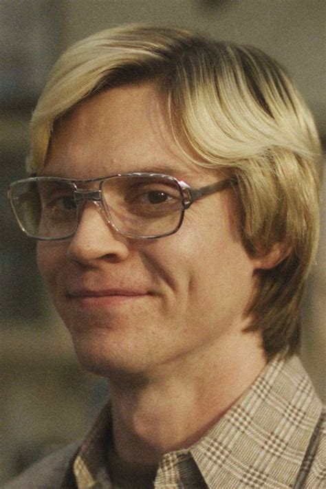 A Man With Blonde Hair And Glasses Smiling