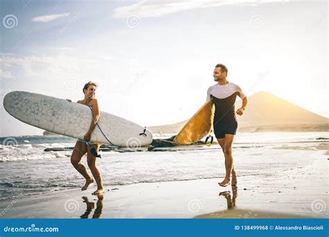 Couple Of Surfers Walking On Coast In Indonesia Royalty Free Stock