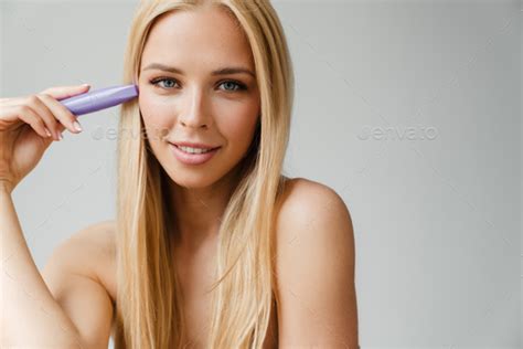 Half Naked Blonde Woman Looking At Camera While Showing Mascara Stock