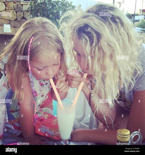 Zwei Blonde M Dchen Teilen Einen Milchshake Mit Z Pfen In Den Haaren Stockfotografie Alamy