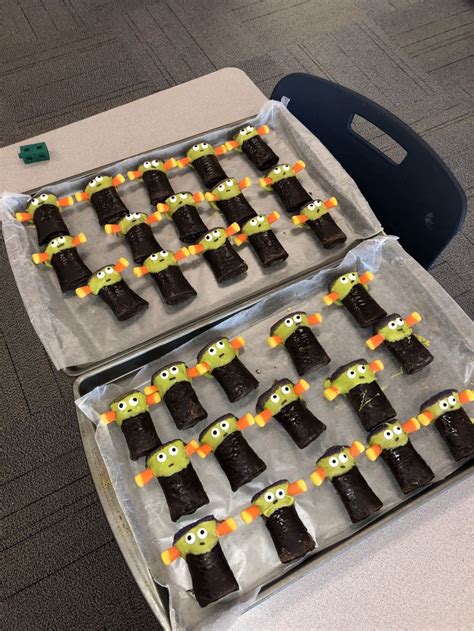 Two Trays Filled With Halloween Treats Sitting On Top Of A Table Next