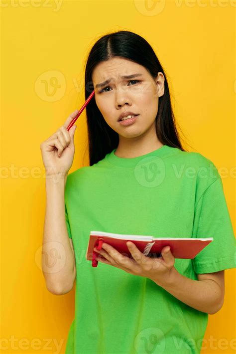 Woman With Asian Appearance Green T Shirts With Red Notebook And Pen