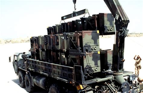 A Crane Is Used To Lift A Canister Containing A MIM 104 Patriot Anti