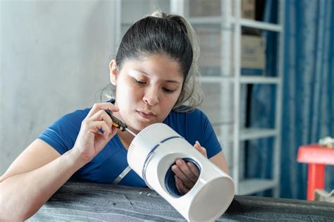 Detalhe De Uma Jovem Latina Tentando Desmontar Um Ventilador Uma Chave De Fenda Foto Premium