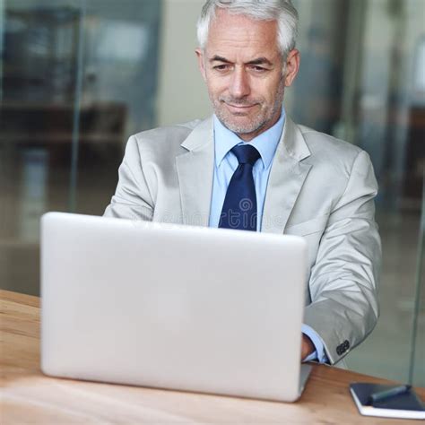Making Business In The Modern Era A Mature Businessman Working On A Laptop In An Office Stock