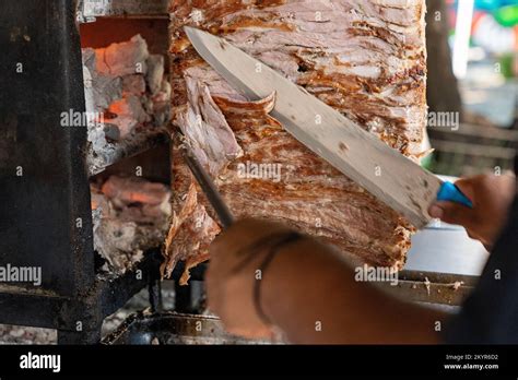 Taquero Slicing Spit Roast Pork Meat For Tacos Al Pastor In Mexico City