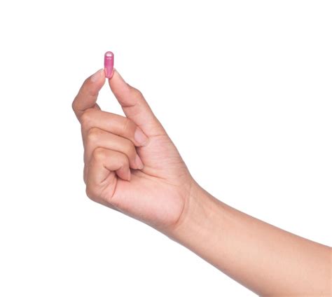 Premium Photo Hand Holding A Pill Between Thumb And Forefinger